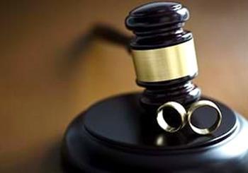 A gavel and wedding rings on a table